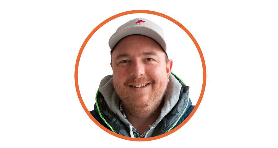 Smiling man wearing a white cap and jacket, with an orange circular frame around his portrait.